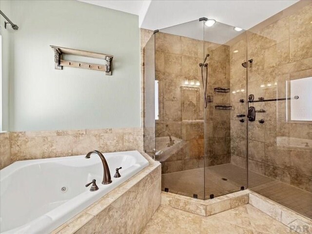 full bathroom featuring a whirlpool tub and a shower stall