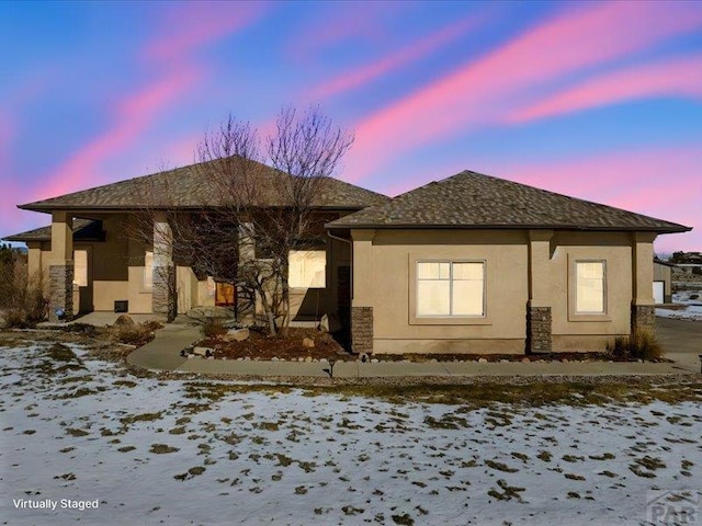 snow covered house with stucco siding