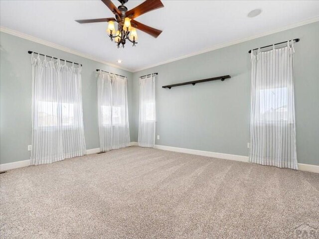 empty room featuring ornamental molding, carpet, and baseboards