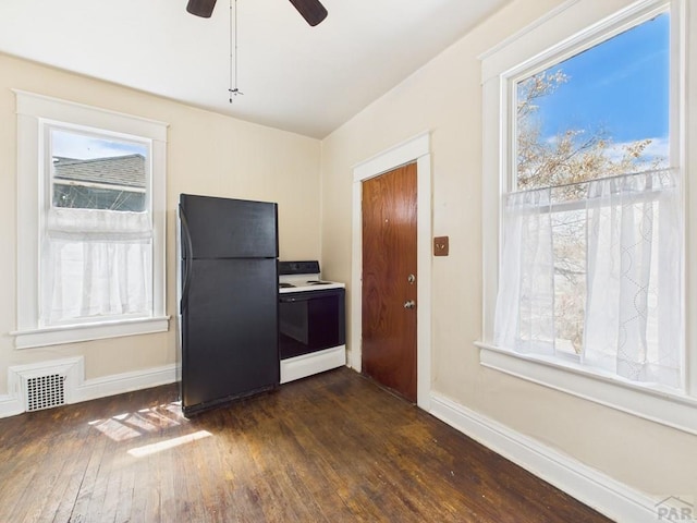 411 Michigan St, Pueblo, CO 81004 - kitchen featuring white electric stove, freestanding refrigerator, dark wood-style floors, a ceiling fan, and healthy amount of natural light