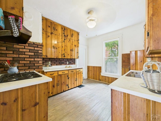 411 Michigan St, Pueblo, CO 81004 - kitchen with a wainscoted wall, light countertops, light wood-style flooring, black gas cooktop, and ceiling fan