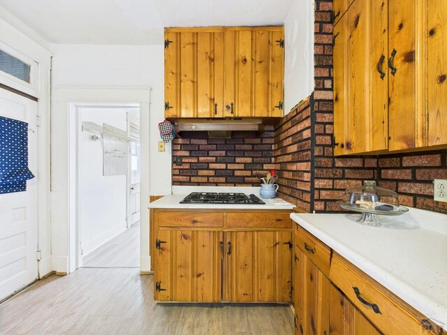 411 Michigan St, Pueblo, CO 81004 - kitchen featuring gas cooktop, light countertops, brown cabinetry, and light wood-style floors
