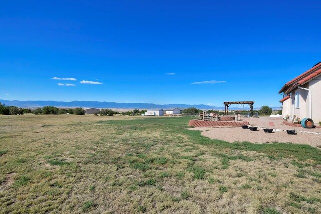 view of yard with a mountain view and a pergola