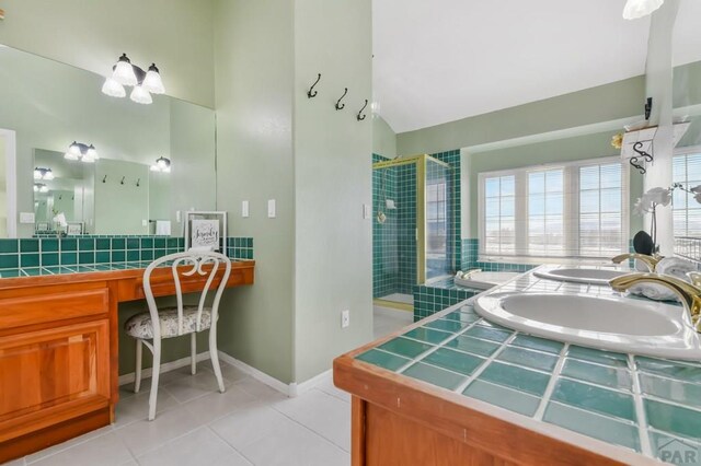 bathroom featuring double vanity, lofted ceiling, a sink, a shower stall, and tile patterned floors