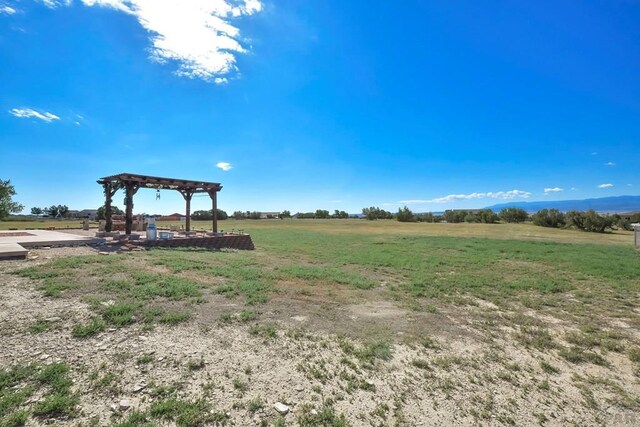 exterior space with a pergola and a rural view