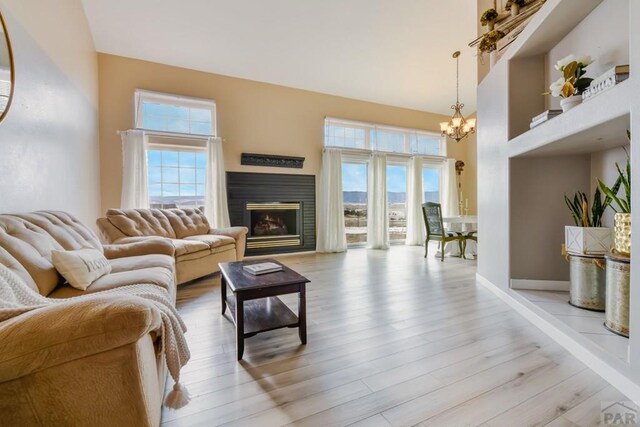 living room with a high ceiling, plenty of natural light, and light wood finished floors