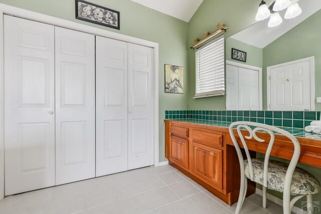 bathroom with vaulted ceiling and tile patterned flooring