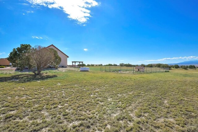 view of yard featuring a rural view and fence