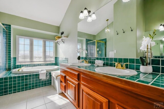 bathroom featuring double vanity, vaulted ceiling, a sink, and tile patterned floors