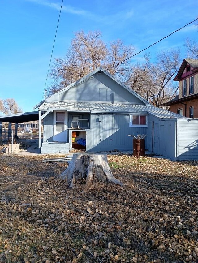 back of property featuring metal roof and an attached carport