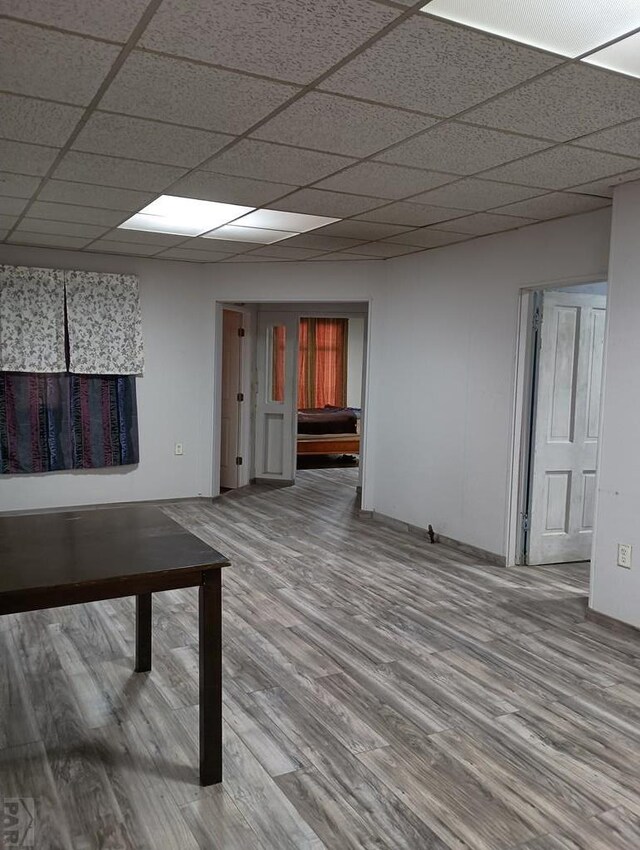 hallway with a drop ceiling and wood finished floors