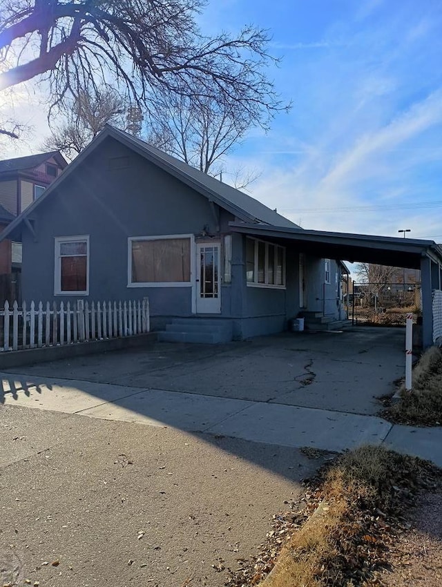 view of front of house featuring entry steps, driveway, and a carport