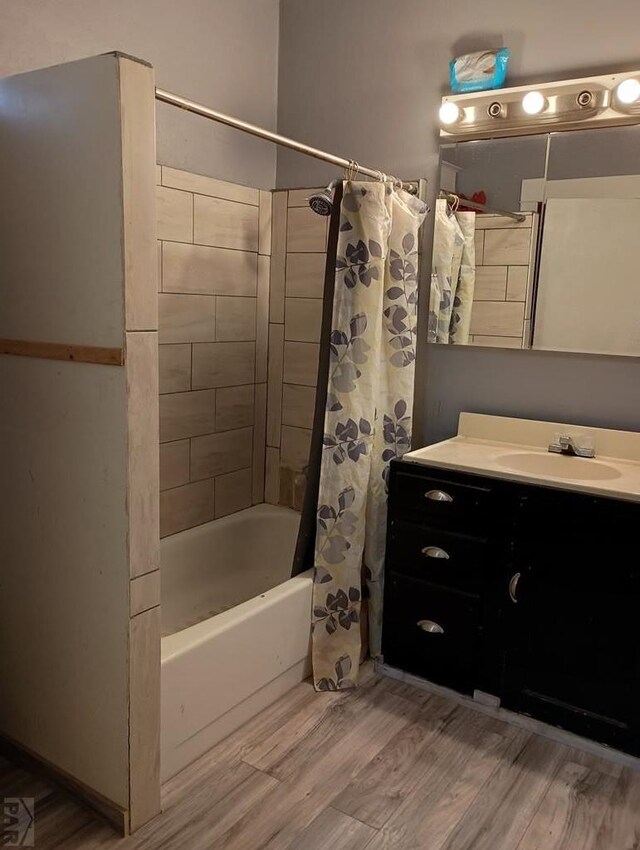 bathroom featuring shower / bath combination with curtain, wood finished floors, and vanity