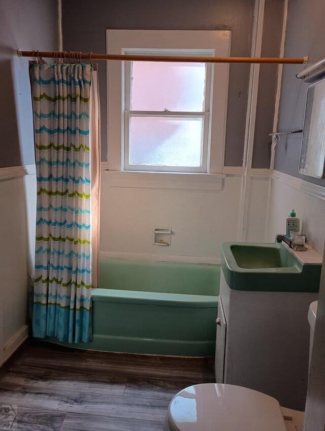 bathroom featuring shower / tub combo with curtain, vanity, toilet, and wood finished floors