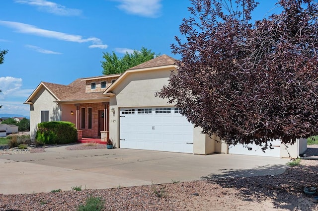 view of front facade featuring driveway, a shingled roof, an attached garage, and stucco siding