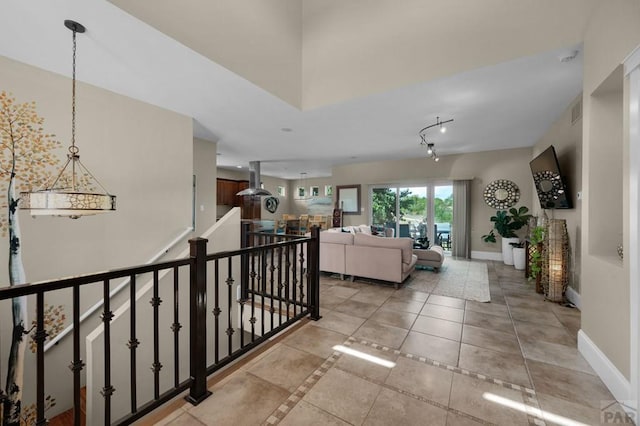 corridor featuring visible vents, baseboards, and light tile patterned floors