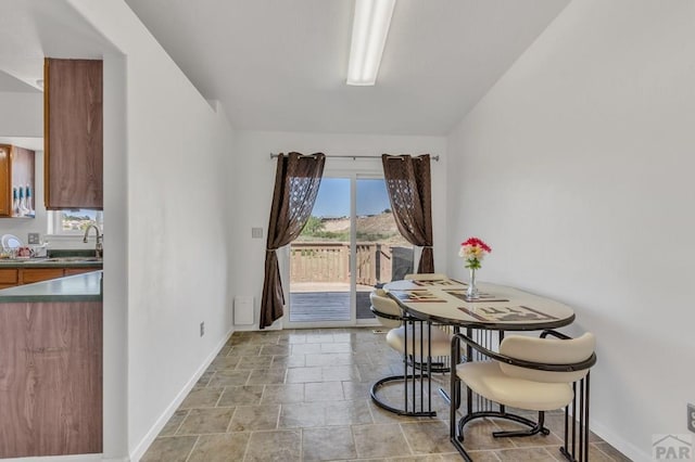 dining area featuring stone finish floor and baseboards