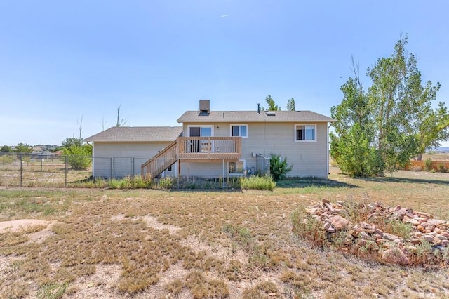 rear view of house featuring fence, stairway, and a wooden deck