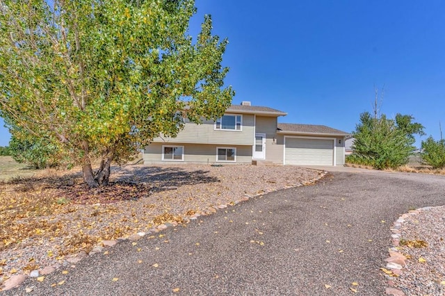 view of front of home featuring an attached garage and aphalt driveway