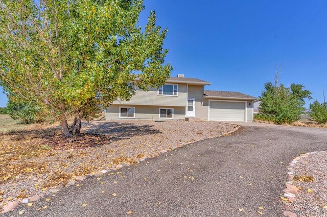 view of front of home featuring an attached garage and aphalt driveway