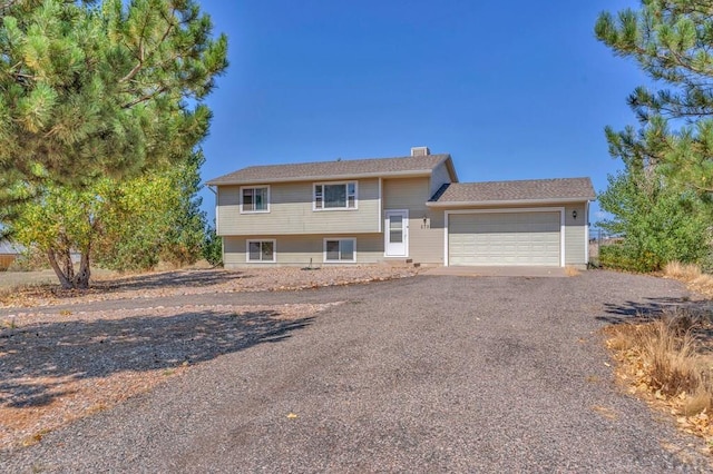 view of front of home featuring a garage and gravel driveway