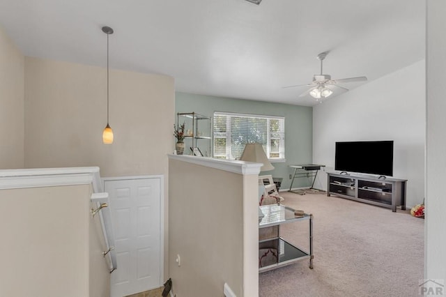 living area with ceiling fan and carpet