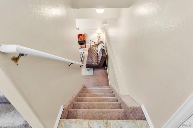 stairs featuring carpet flooring and baseboards