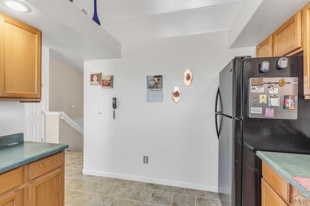 kitchen with freestanding refrigerator and baseboards