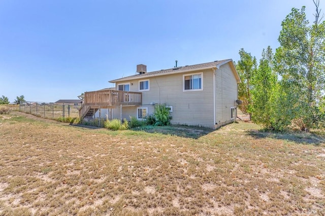 back of property with fence, stairway, a deck, and a yard