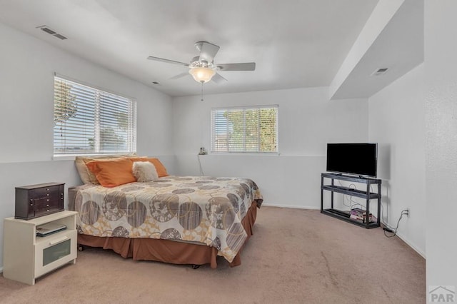 bedroom with baseboards, a ceiling fan, visible vents, and light colored carpet