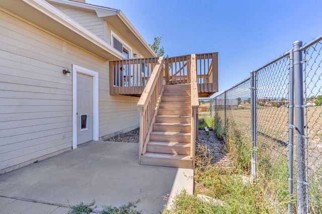 exterior space with a deck, stairway, and fence