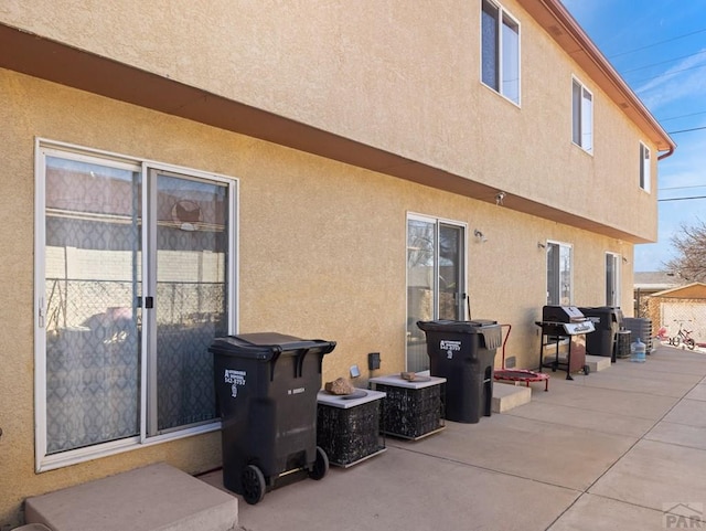 back of house with a patio and stucco siding