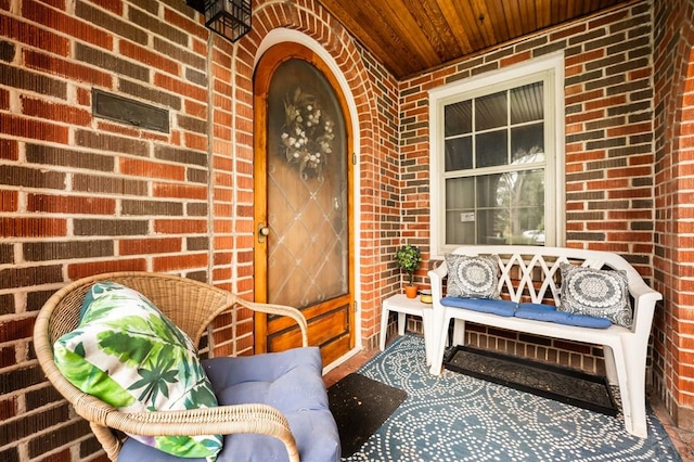 property entrance with covered porch and brick siding