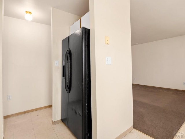 kitchen with light carpet, light tile patterned floors, white cabinetry, and black refrigerator with ice dispenser