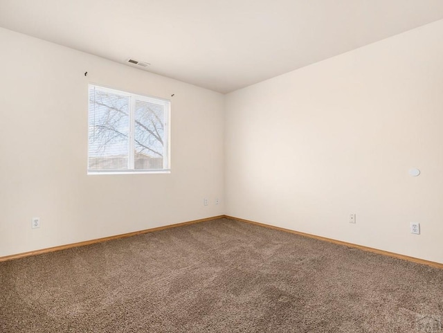 carpeted spare room with visible vents and baseboards