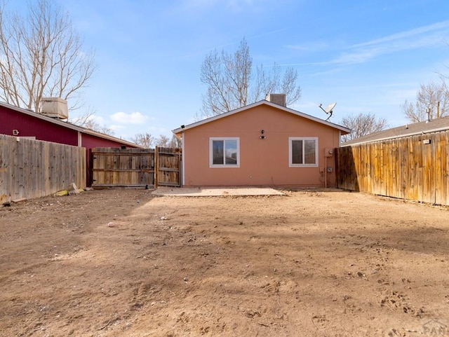 rear view of house with a chimney, a patio area, and a fenced backyard