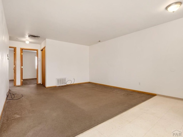 empty room with carpet floors, visible vents, and baseboards