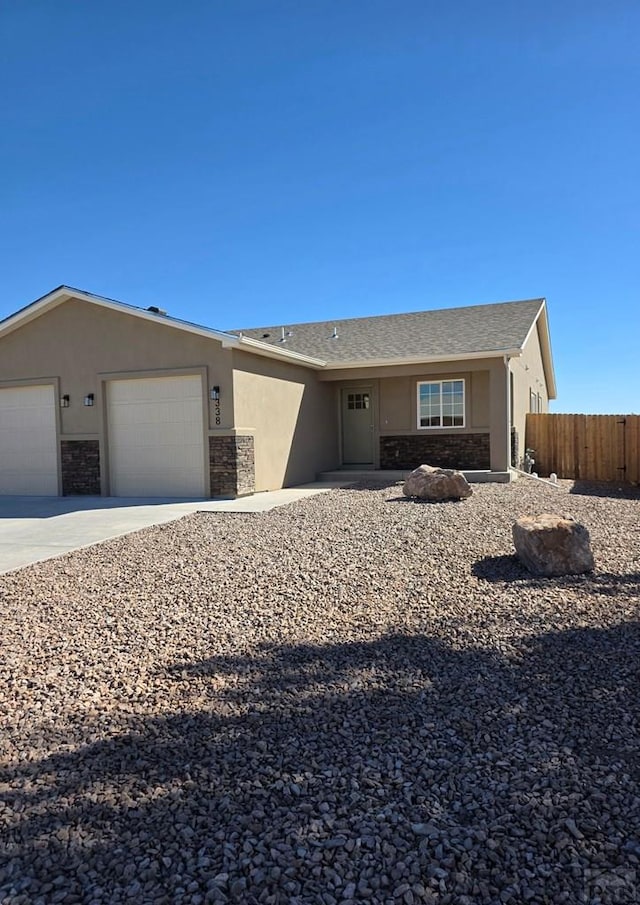 ranch-style house with an attached garage, stone siding, fence, and stucco siding