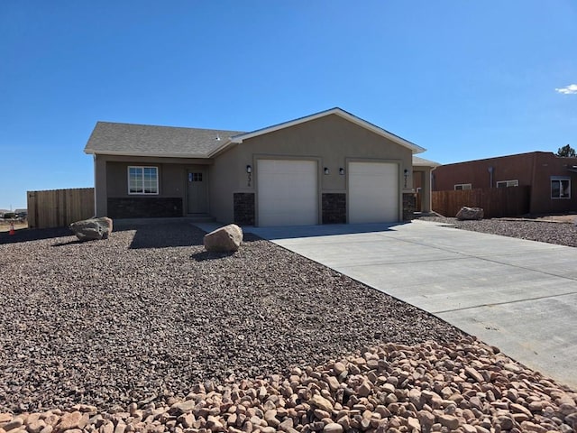 single story home featuring stucco siding, concrete driveway, an attached garage, fence, and stone siding