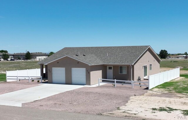 ranch-style home featuring fence, driveway, and stucco siding