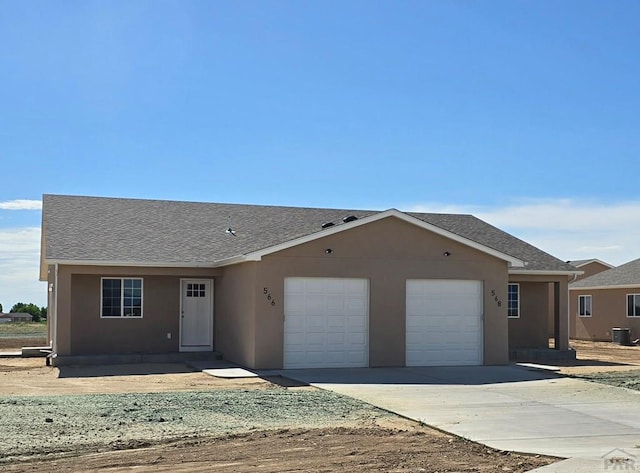 ranch-style house featuring a garage, roof with shingles, driveway, and stucco siding