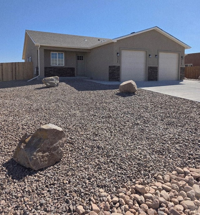 single story home featuring concrete driveway, fence, an attached garage, and stucco siding