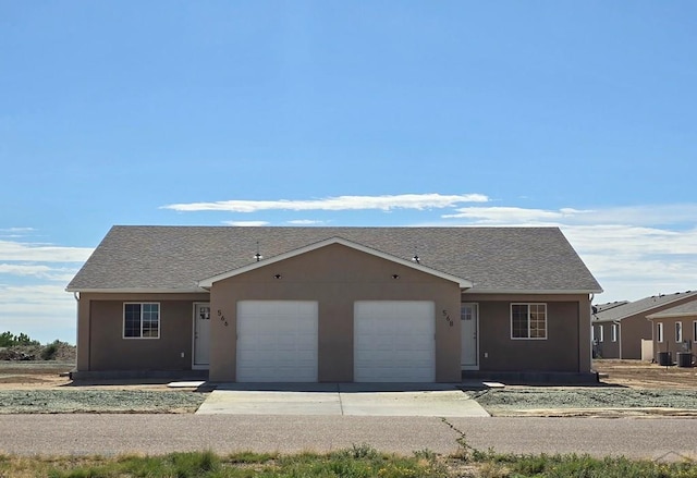 ranch-style house featuring an attached garage, driveway, roof with shingles, and stucco siding