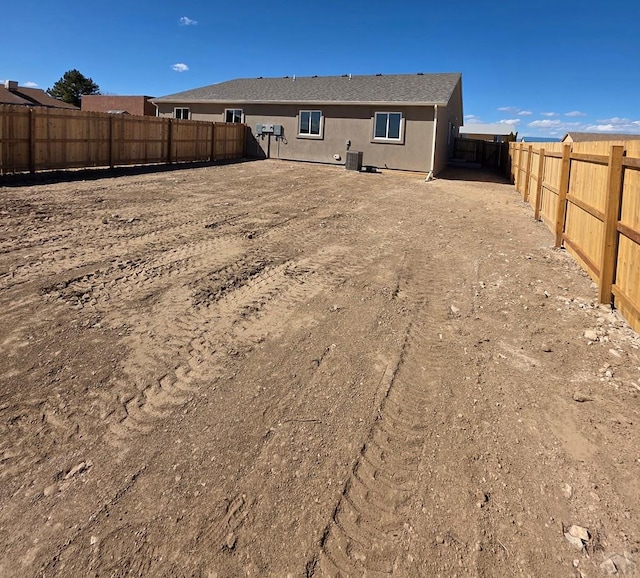 back of house featuring a fenced backyard and stucco siding