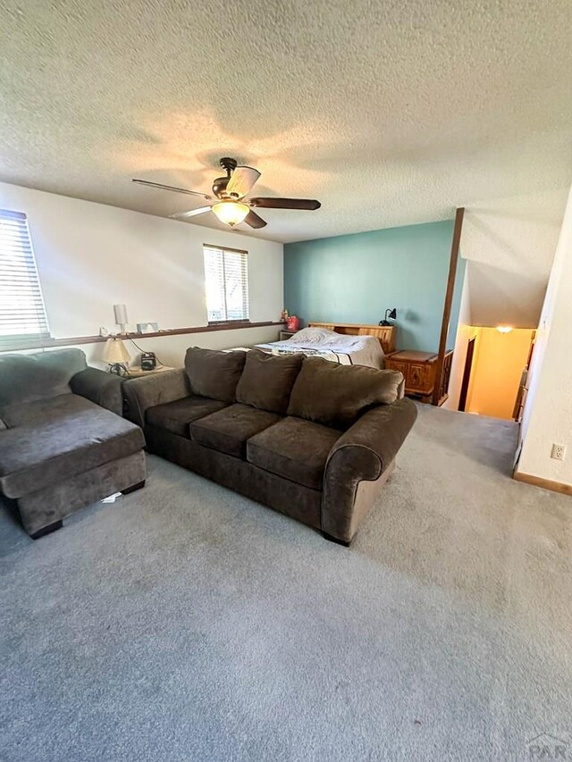 living room with carpet floors, ceiling fan, and a textured ceiling