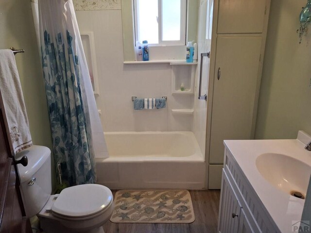 full bath with shower / tub combo with curtain, vanity, toilet, and wood finished floors