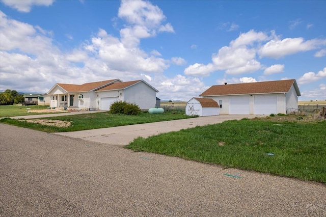 49 N Pkwy, Colorado City, CO 81019 - view of side of home featuring concrete driveway, a lawn, stucco siding, and a garage