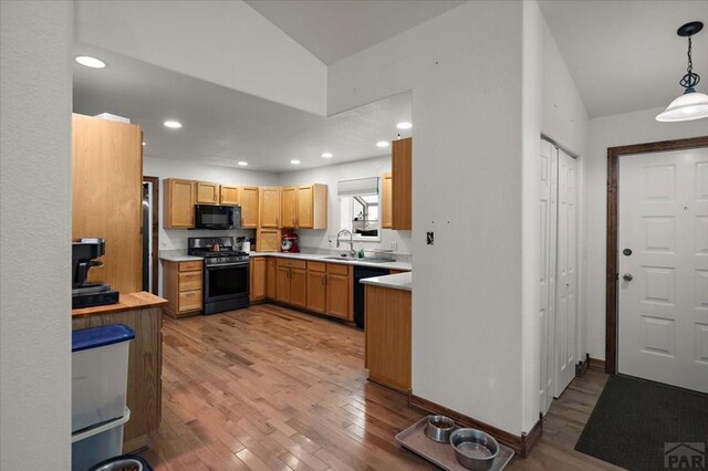 49 N Pkwy, Colorado City, CO 81019 - kitchen featuring black appliances, a sink, light countertops, light wood-style floors, and hanging light fixtures