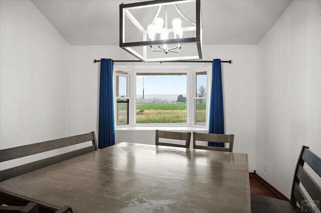 49 N Pkwy, Colorado City, CO 81019 - unfurnished dining area featuring a chandelier, baseboards, and wood finished floors