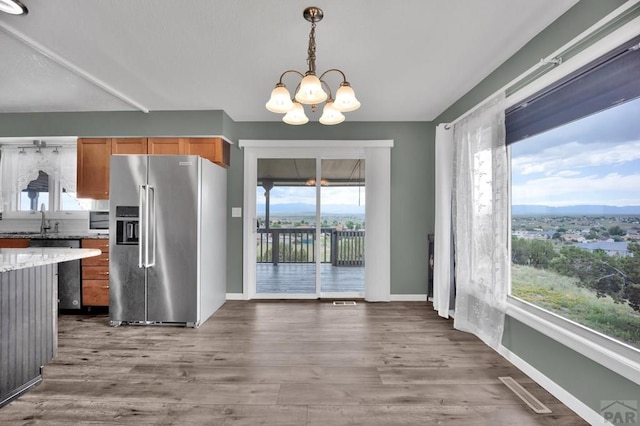 452 S Siesta Ln, Pueblo West, CO 81007 - kitchen with high end fridge, a chandelier, wood finished floors, dishwashing machine, and pendant lighting